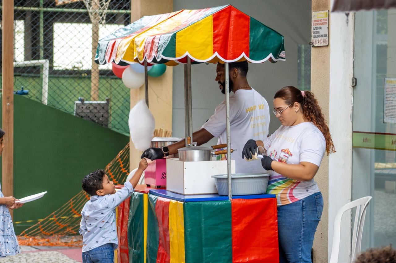 Crianças felizes brincando em piscina de bolinhas e cama elástica